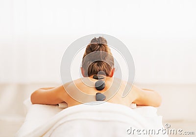 Young woman receiving hot stone massage. rear view Stock Photo