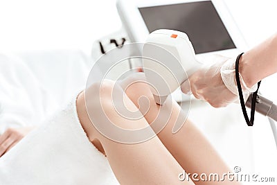 Young woman receiving laser skin care on leg Stock Photo