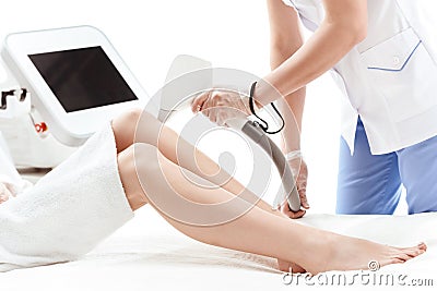 Young woman receiving laser skin care on legs Stock Photo