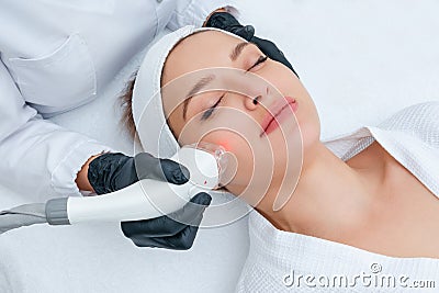 Young woman receiving laser treatment in cosmetology clinic Stock Photo