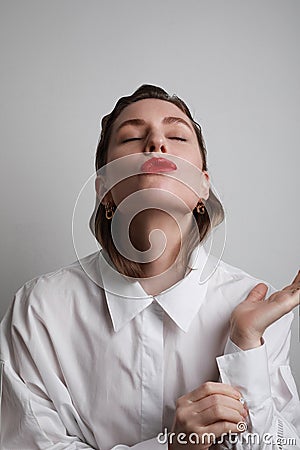 Young woman with red lips sending air kiss. Playful and romantic mood. Love concept. Stock Photo