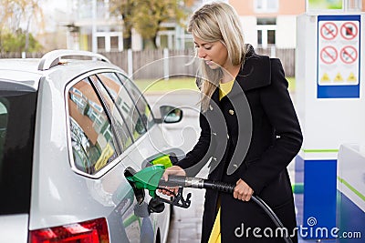 Young woman refilling petrol in gas station Stock Photo