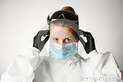 Young woman regulate medical mask with her hands Stock Photo