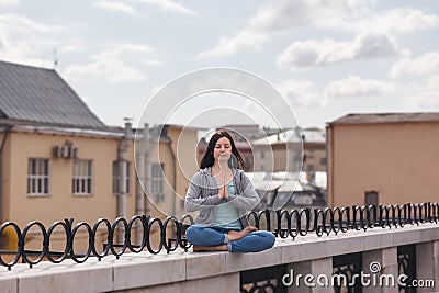 Young woman in a relaxing pose on the parapet Stock Photo