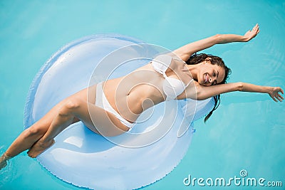 Young woman relaxing on swim ring at swimming pool Stock Photo