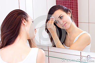 Young woman removing makeup in bathroom Stock Photo