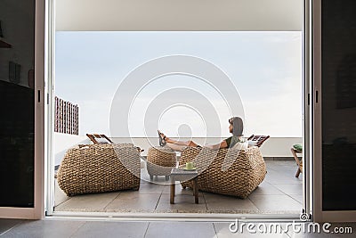 Young woman resting on terrace at home. Beautiful girl enjoying life. Vacations, relaxation and summer fun concept Stock Photo