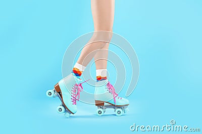 Young woman with retro roller skates on color background Stock Photo