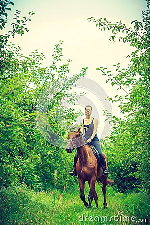 Young woman ridding on a horse Stock Photo