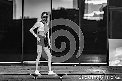 Young woman rides a longboard. Stock Photo