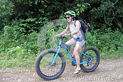 Young woman rides push up mountain bikes in Rarotonga Cook Islands Editorial Stock Photo