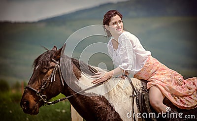 Young woman riding on beautiful horse , having fun in summer time , Romania countryside Editorial Stock Photo