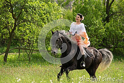 Young woman riding on beautiful horse , having fun in summer time , Romania countryside Editorial Stock Photo