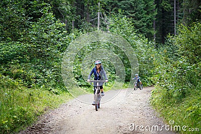 Young woman riding bicycle in mountain forest Stock Photo