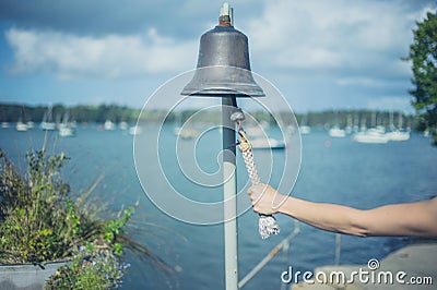 Woman ringing bell to call boatman Stock Photo