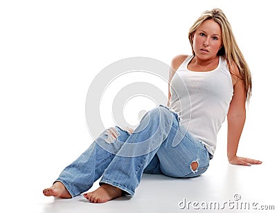 Young woman with ripped jeans sitting down Stock Photo