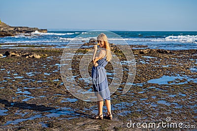 A young woman on a rocky cosmic Bali shore Stock Photo