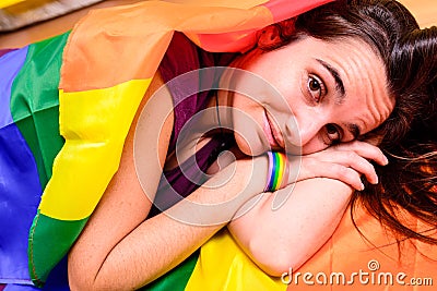 Young woman rolled up in a gay pride flag Stock Photo