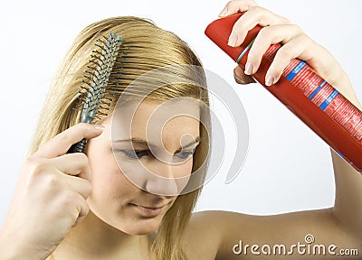 Young woman with roller comb and hairspray Stock Photo