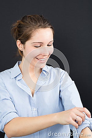 Young woman rolling up her shirt sleeves Stock Photo