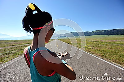 Young woman runner ready to run set and looking at sports smart watch Stock Photo