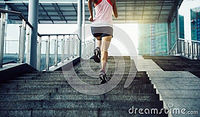 Woman running up city stairs Stock Photo