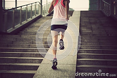 Woman running up city stairs Stock Photo