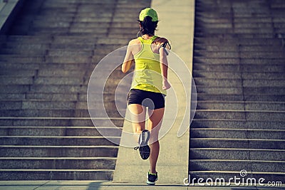 Woman running up city stairs Stock Photo