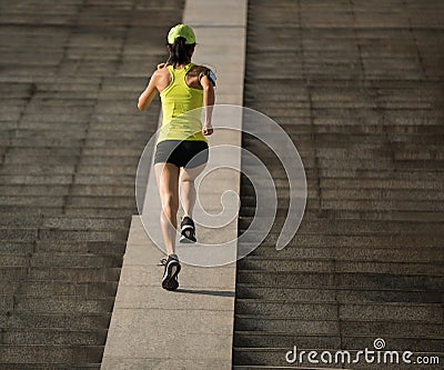 Woman running up city stairs Stock Photo