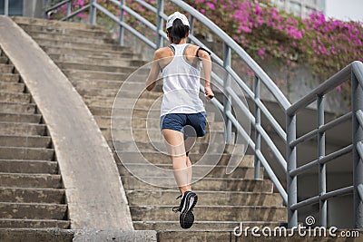 sportswoman running up city stairs Stock Photo