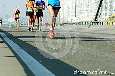 Young woman running on city bridge road. Female leader athlete runner running city marathon. Marathon running in the morning Editorial Stock Photo