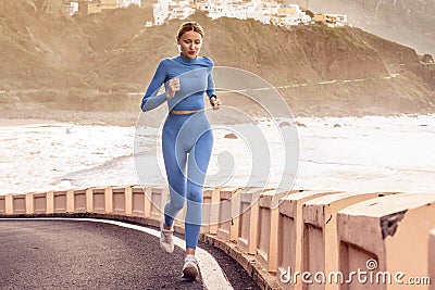 Young woman running, coastal ocean view Stock Photo