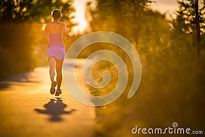 Young woman running outdoors on a lovely sunny summer evenis Stock Photo