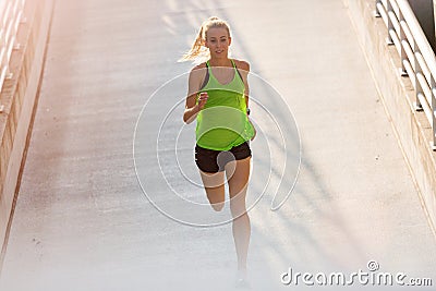 Young woman running on parking level in the city at sunset Stock Photo