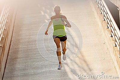 Young woman running on parking level in the city at sunset Stock Photo