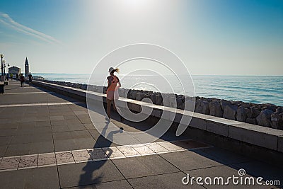 A young woman runs along the sea Editorial Stock Photo