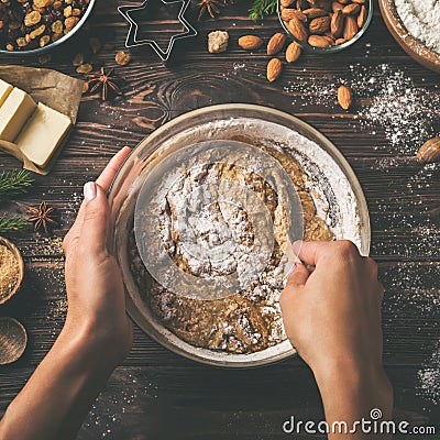 Young woman`s hands cooking christmas fruit cake. Wooden table with baking ingredients Stock Photo