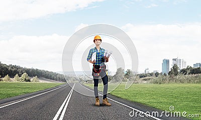 Young woman in safety helmet standing on road Stock Photo