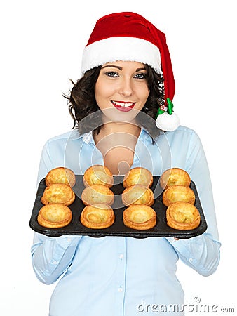 Young Woman in Santa Hat Holding a Tray of Yorkshire Puddings Stock Photo