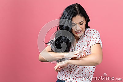 Young woman scratching her itchy arm. Stock Photo