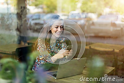 Woman seen through cafe window Stock Photo