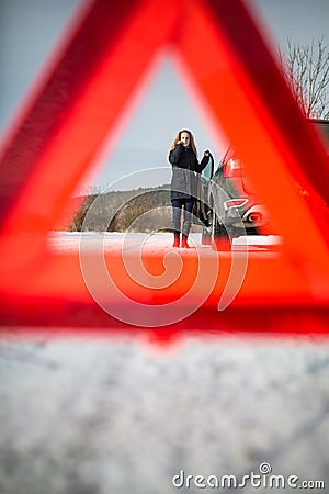 Young woman setting up a warning triangle and calling for assistence Stock Photo