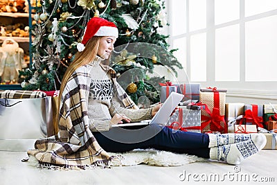 Young woman shopping online in cozy christmas interior Stock Photo