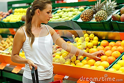 Young woman shopping in a supermarket in the department of fruit Stock Photo