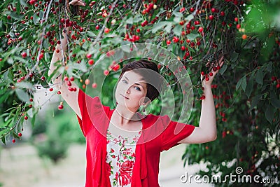 Young woman with short hair-cut standing near cherry tree Stock Photo