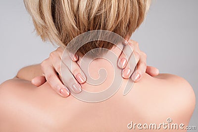 Young woman with shoulder pain, massaging her shoulder Stock Photo