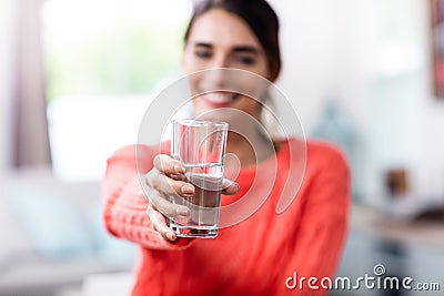 Young woman showing drinking glass with water Stock Photo