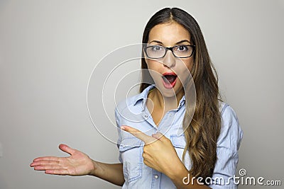 Young woman showing product with open hand palm and pointing finger. Excited expression on businesswoman wearing glasses isolated Stock Photo