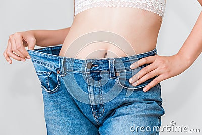 Young woman showing successful weight loss with her jeans, Healthcare, Diet concept Editorial Stock Photo