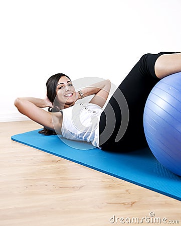 Young woman sit up with ball Stock Photo